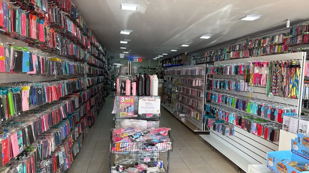 Corredor da loja com paredes cheias de capinhas penduradas
